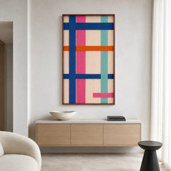 Clean entryway setting highlighting the vertical framed wool wall art hanging above a modern low wooden credenza in a bright room.