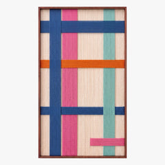 Full product shot of the vertical hand-woven wool wall art in a sleek metal frame, displaying geometric blocks of blue, orange, pink, and teal yarn.