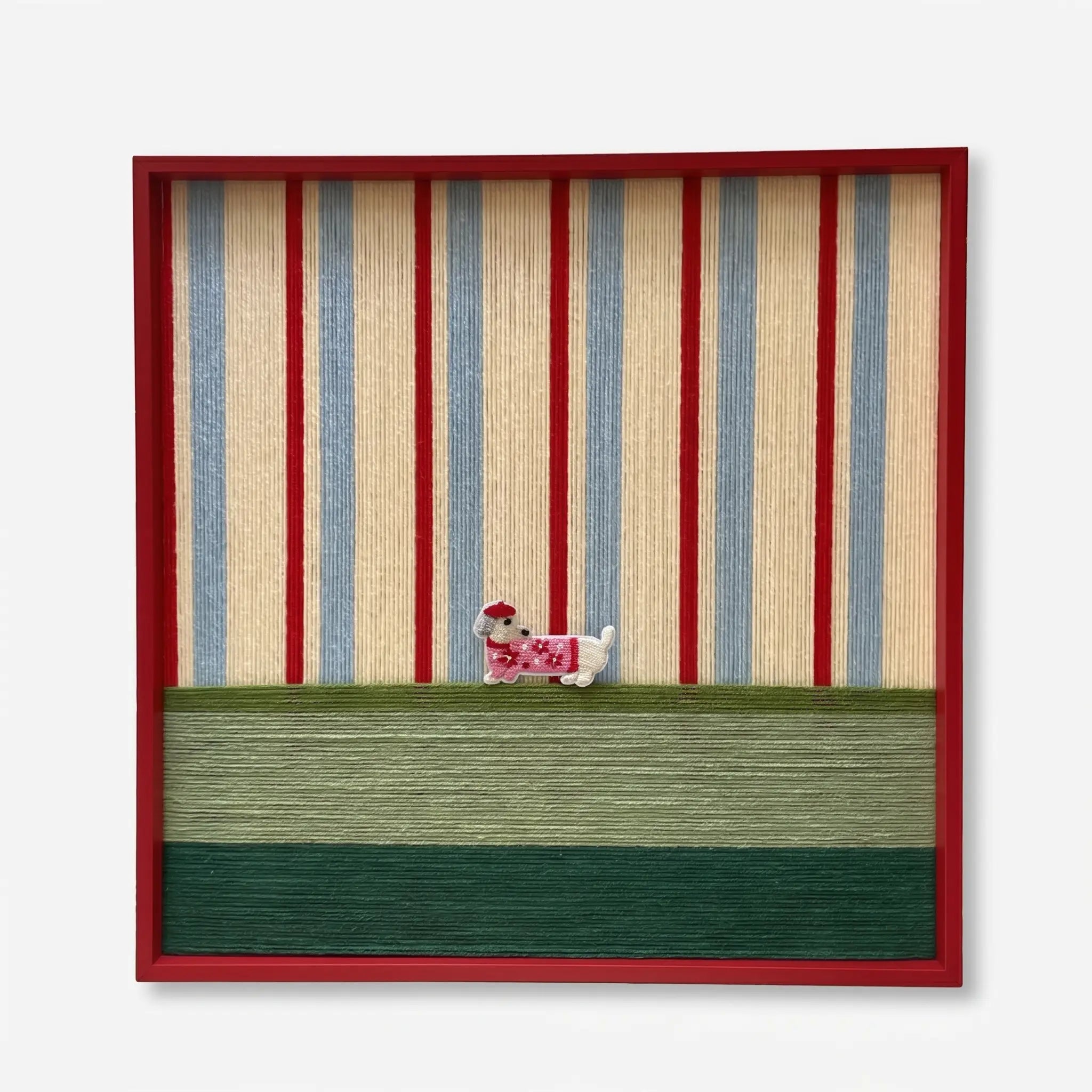 Professional studio shot of the Scarlet Stripe Pup hand-woven wool wall art in a red frame against a white background.