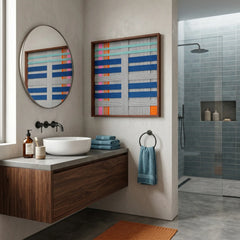 Vibrant framed hand-woven wool tapestry displayed in a modern luxury bathroom above a floating wooden vanity with a circular mirror.