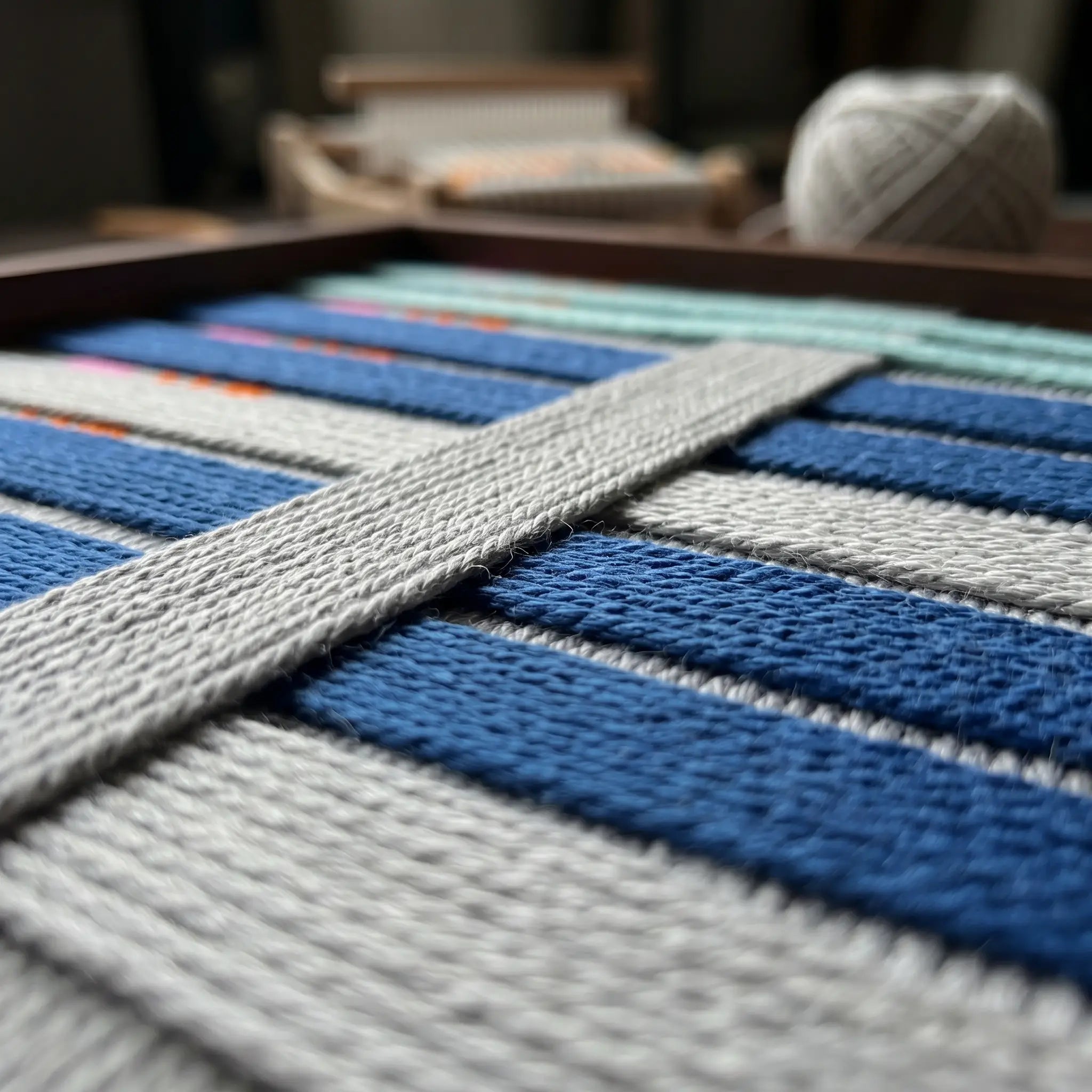 Macro close-up of the Silent Dopamine fiber art highlighting the structural layering of the raised grey yarn over horizontal blue bands.