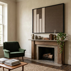 The Silent Stelae hand-woven tapestry hangs elegantly above a classic fireplace, styled with an olive armchair to create a serene living room.