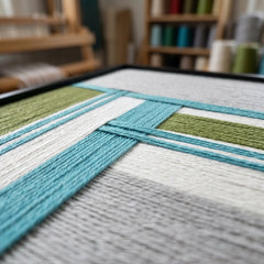 Close-up angled shot of the Silent Stream fiber art highlighting the intricate hand-wrapped wool yarn and layered textile patterns.