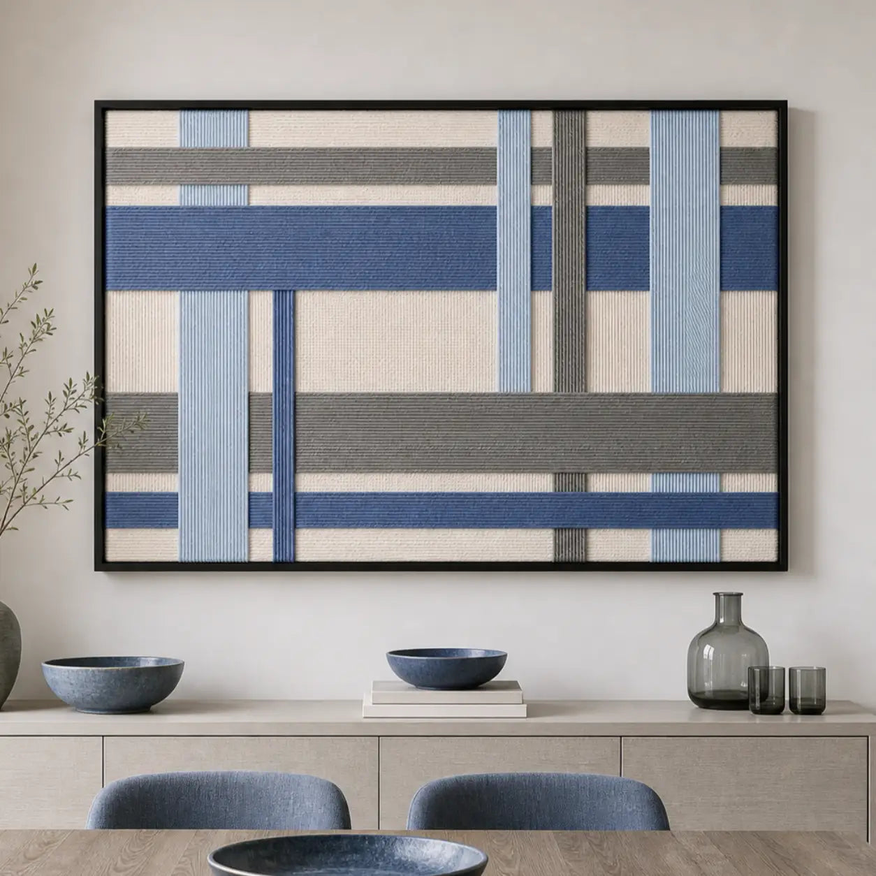 Blue and grey geometric hand-woven wool tapestry beautifully staged in a bright dining room over a sleek wooden sideboard.