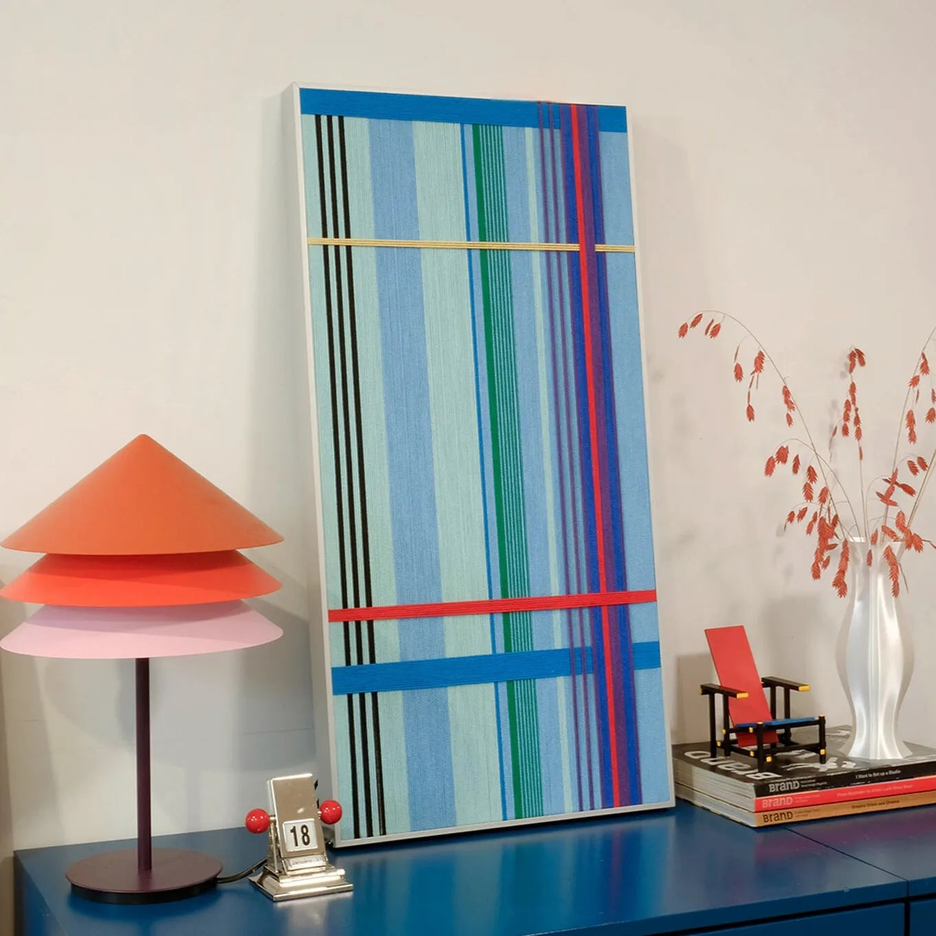 Angled view of Summer Story yarn wall art showing precise stitch detail and vibrant color layering of the stripe panels
