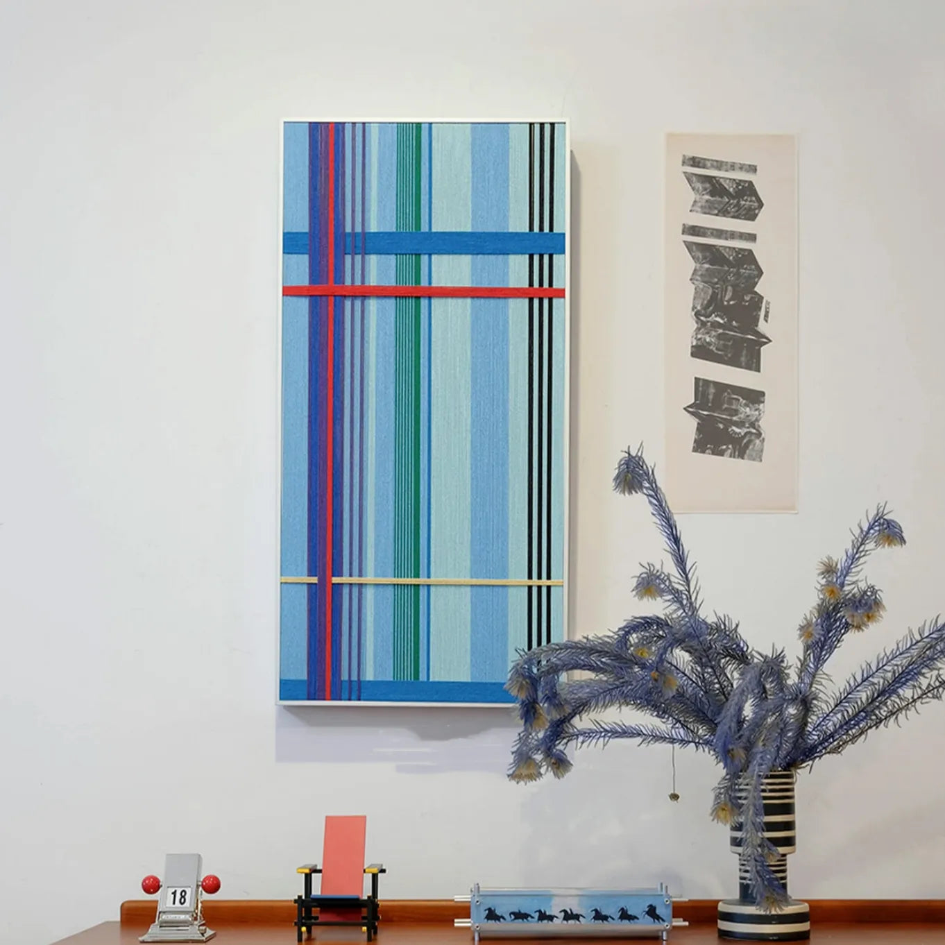 Summer Story yarn wall art styled on a desk beside a lamp and notebook, emphasizing its balanced horizontal stripe design
