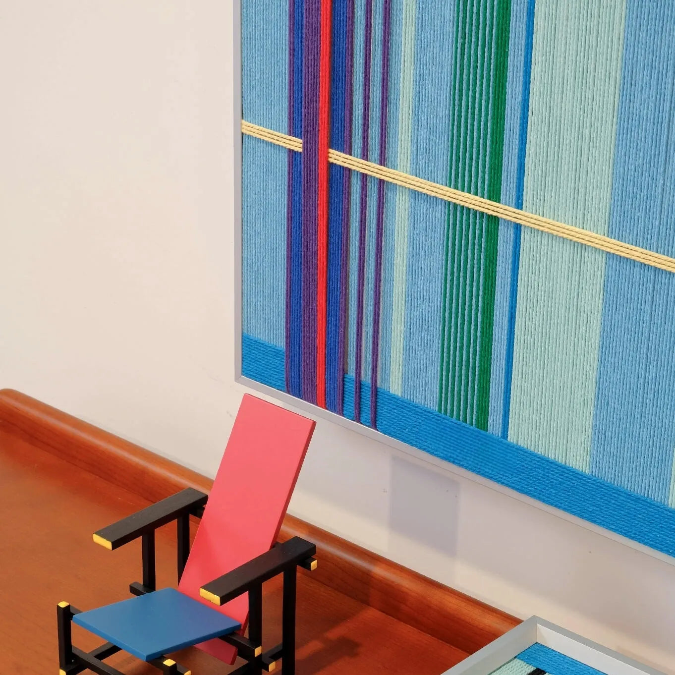 Summer Story wall art propped on a laptop, highlighting its compact square format and framed design
