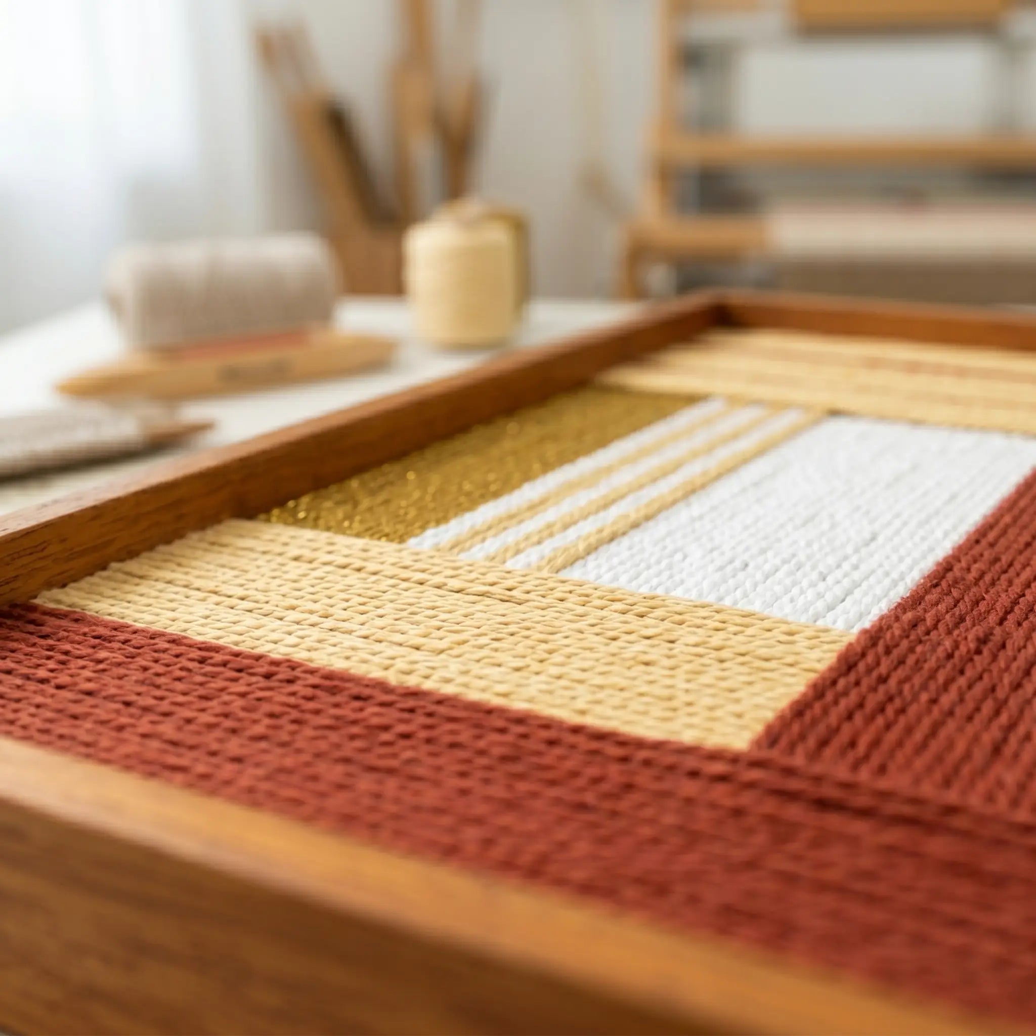 Perspective shot of the fiber wall art in an artist studio, showcasing the dimensional quality and craftsmanship of the woven wool yarn.