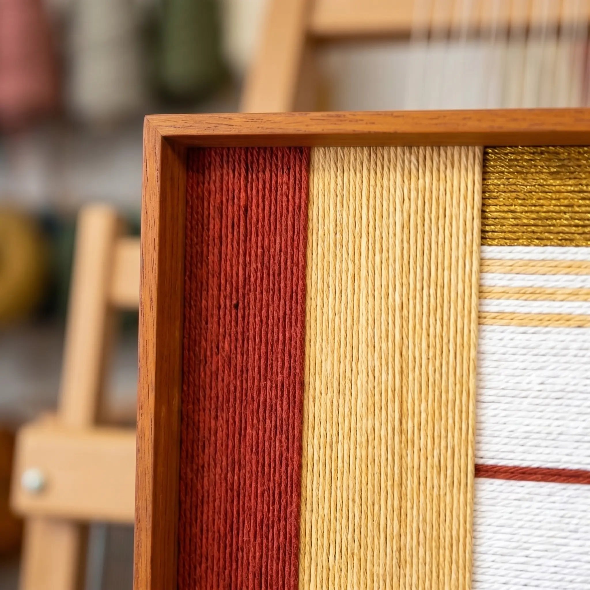 Close-up shot of the oak wood frame corner highlighting the rich, tactile hand-woven wool textures and precise layered winding technique.