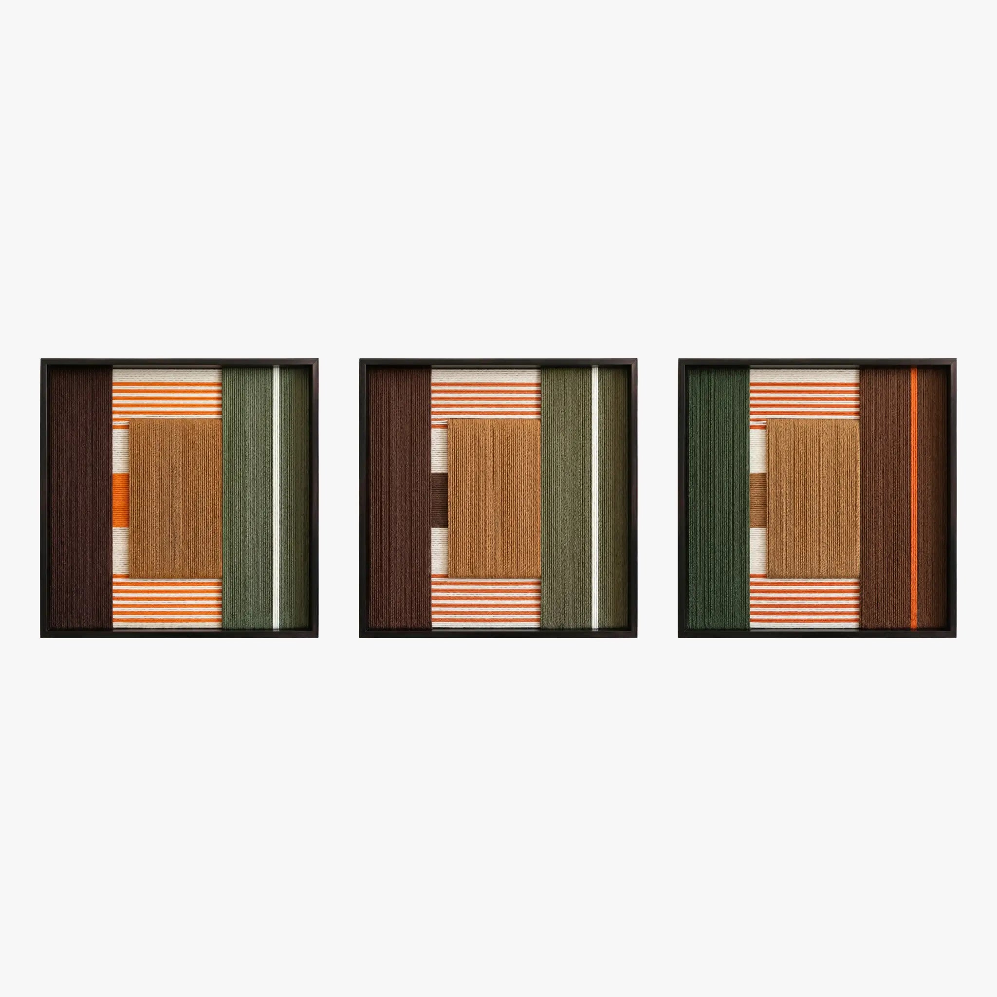 Frontal studio shot of the Sylvan Glow triptych, showcasing three matching square hand-woven wall art pieces with green, tan, and rust geometric designs in black frames.