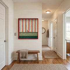 Framed striped textile wall art styled in a bright, modern hallway above a simple wooden bench.