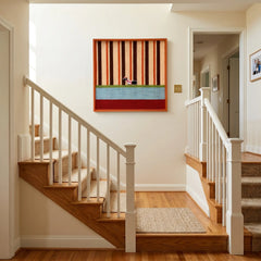 Framed striped textile wall art styled on a bright white wall above a wooden staircase landing.
