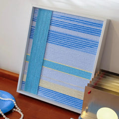 That Summer, the Blue Sea hand-woven yarn wall art with seamless light-to-dark blue gradient stripes in a solid wood frame

